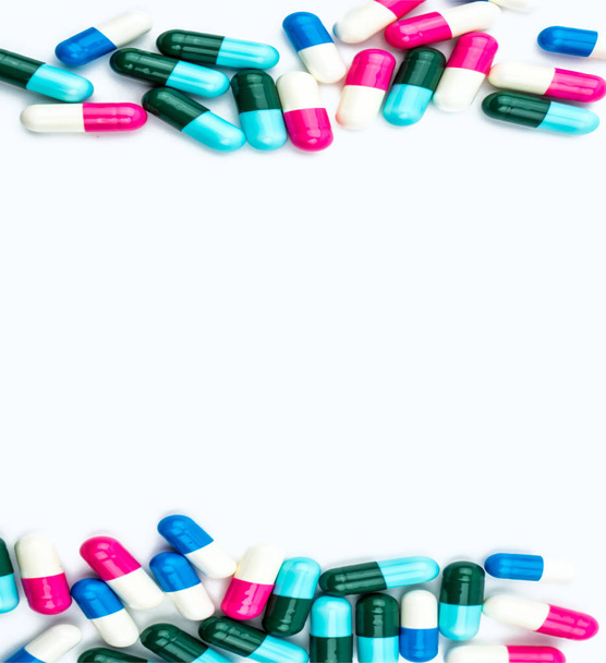 Kleurrijk antibiotica capsules pillen geïsoleerd op een witte achtergrond met kopie ruimte. Resistentie tegen geneesmiddelen, gebruik van antibiotica drugs met redelijke, gezondheidsbeleid en ziektekostenverzekering concept. - Foto, afbeelding