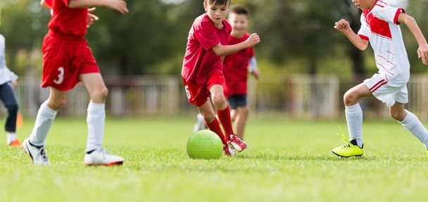 Niños pequeños jugadores partido de fútbol en el campo de fútbol
 - Foto, Imagen