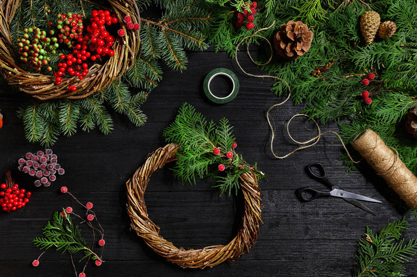 Kendi ellerinle bir Noel çelenk olun. Ladin şube, Noel çelenk ve hediyeler siyah ahşap zemin - Fotoğraf, Görsel