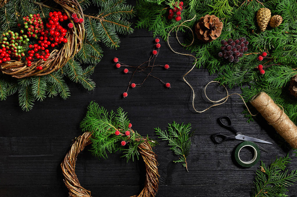 Kendi ellerinle bir Noel çelenk olun. Ladin şube, Noel çelenk ve hediyeler siyah ahşap zemin - Fotoğraf, Görsel