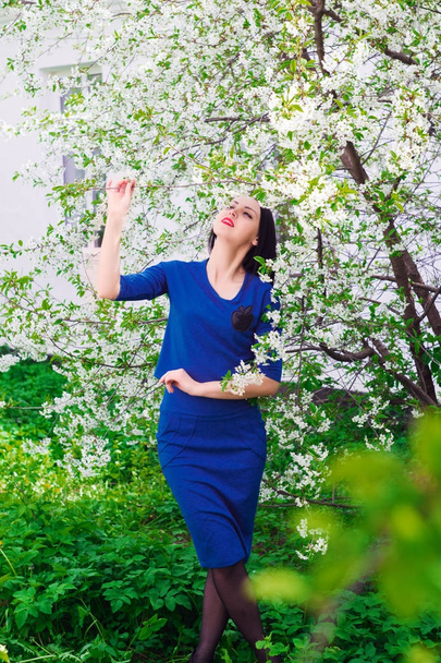 Young beautiful woman in spring blossoming garden - Foto, afbeelding