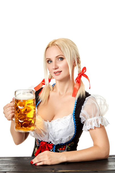 Camarera en traje alemán tradicional sosteniendo vaso de cerveza en Oktoberfest
. - Foto, imagen