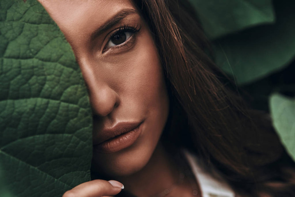 woman face among green leaves - Фото, зображення