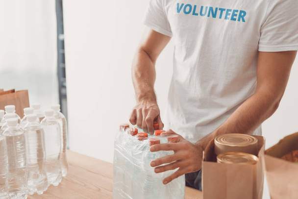volunteer opening pack of water bottles - Foto, immagini