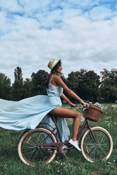 Bisiklet süren genç bir kadın - Fotoğraf, Görsel