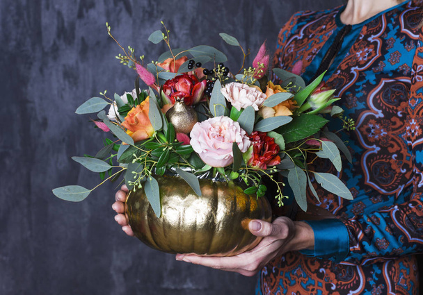 Ramo de flores de otoño en jarrón de cachorro. Decoración floral en manos de mujer
 - Foto, imagen