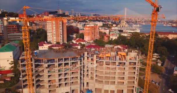 Vista ascendente aérea da casa sob constação, guindastes de trabalho no centro da cidade
 - Filmagem, Vídeo