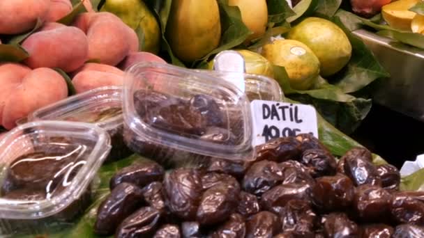 Various tropical fruits mango kiwi peaches dates on food market counter - Footage, Video