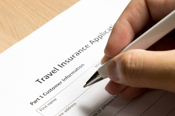 Homem esperar para preencher informações em formulário de inscrição de seguro de viagem no fundo mesa
 - Foto, Imagem