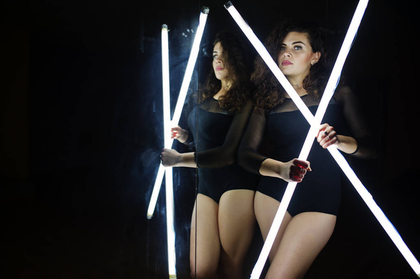 Curly brunette plus size model with two long led lamp at dance r - Фото, зображення