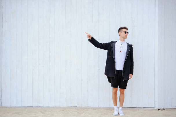 fervent fashionable man on a white wall. Raises his hands to the - Photo, Image
