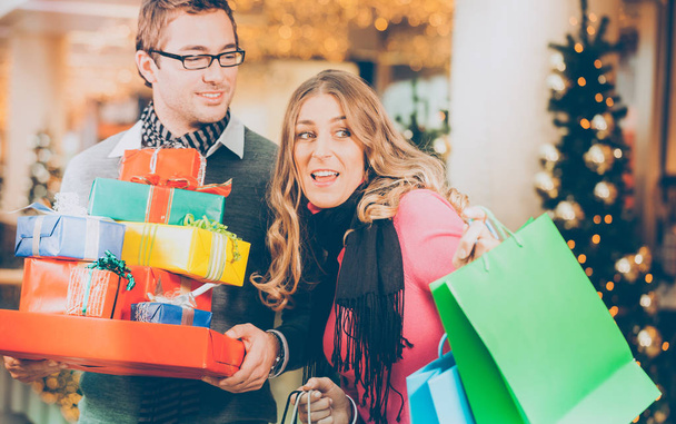 Пара покупает рождественские подарки в торговом центре
 - Фото, изображение