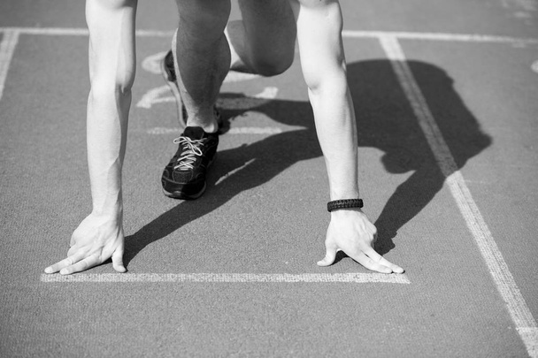 hombre corredor con las manos musculosas, las piernas comienzan en pista de atletismo
 - Foto, imagen