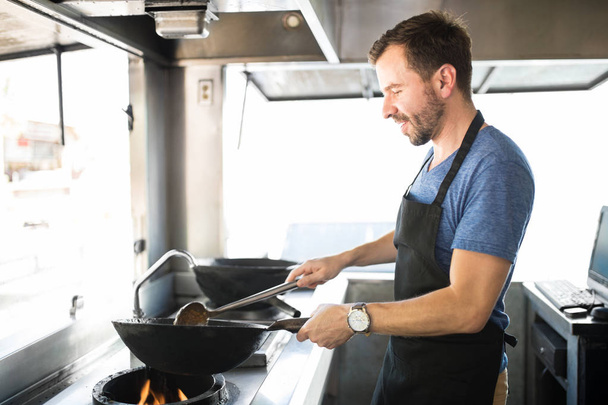 Chef masculino cocinando en un camión de comida
 - Foto, Imagen