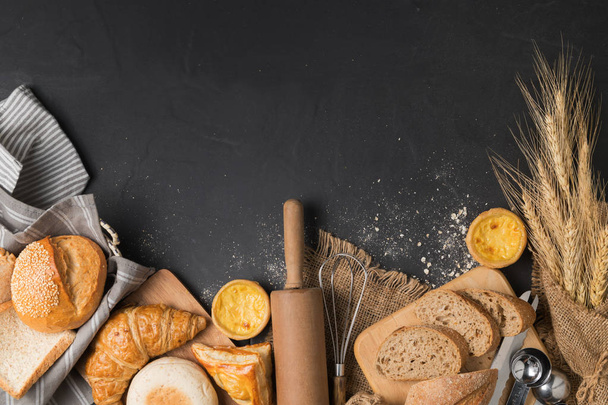 pan e ingredientes de panadería sobre fondo de piedra negra
 - Foto, Imagen
