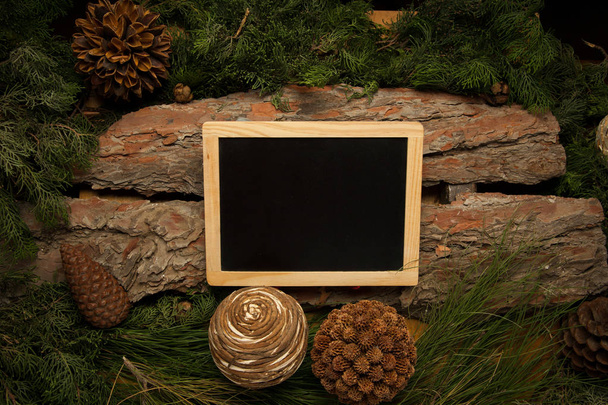 Blackboard with on wooden background with branches of pine - Photo, Image