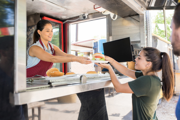 Mujer sirviendo comida al cliente
 - Foto, Imagen