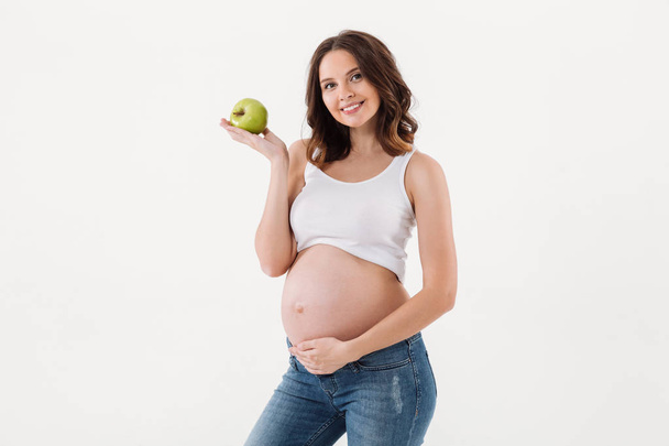 Cheerful pregnant woman eating apple - Foto, Imagem