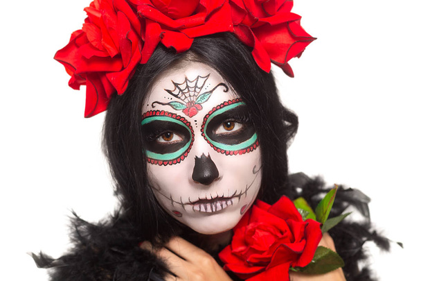 Tag der Toten. Halloween. junge Frau am Tag der Totenmaske Totenkopf Gesichtskunst und stieg auf. isoliert auf weiß. Nahaufnahme. - Foto, Bild
