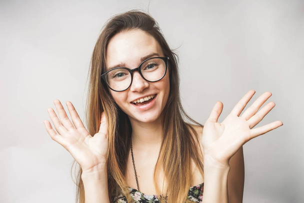 Happy funny woman shows hands,wearing glasses, smiling - Photo, Image