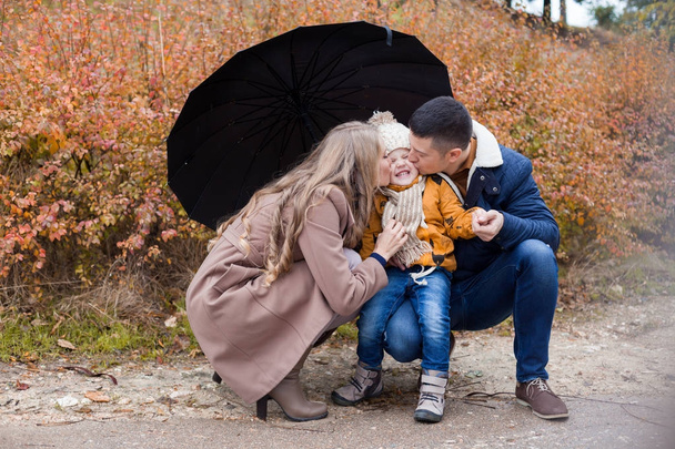 family autumn in the Park in the rain umbrella - Foto, Imagen
