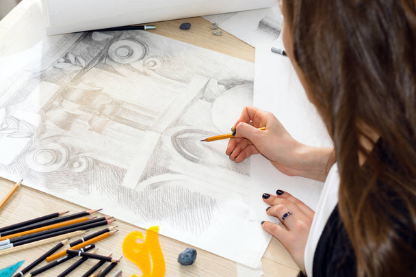 die Hände des Architekturstudenten mit einem Bleistift, der ein Muster aus Licht und Schatten vorbereitet, entwerfen Baluster Nahaufnahme auf einem Holztisch - Foto, Bild