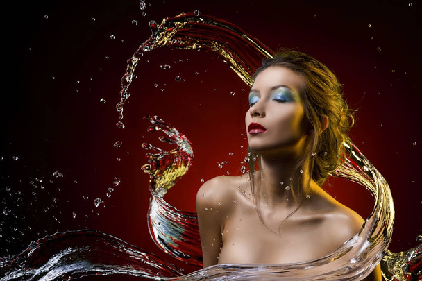 hermosa chica cubierta con agua salpicadura sobre un fondo rojo
 - Foto, Imagen