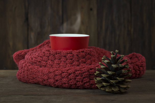Tasse, roter Schal, Fichtenkegel auf Holzgrund - Foto, Bild