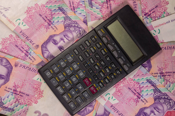 Calculadora sobre o ucraniano duzentas contas hryvnia fundo
 - Foto, Imagem