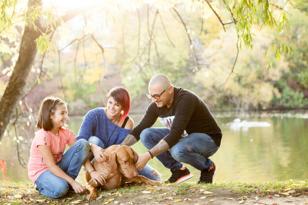 Gorgeous family of father, mother and daughter on the riverside - Photo, image