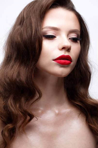 A young girl with a Hollywood wave and classic makeup. Beautiful model with red lips and arrows on eyes. Evening makeup and hairstyle.  - Foto, Bild