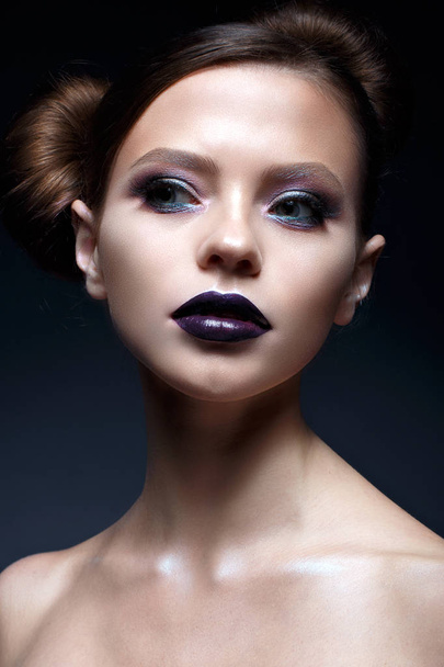 Young girl with creative makeup and hairdo. A beautiful model with bright eyes and purple lips. Shining skin. - Фото, изображение
