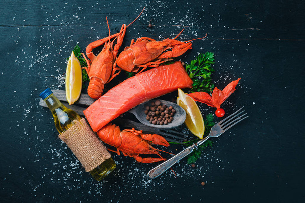 Seafood. Fish Vomer, lobster, salmon. On a wooden background. Top view. Free space for text. - 写真・画像