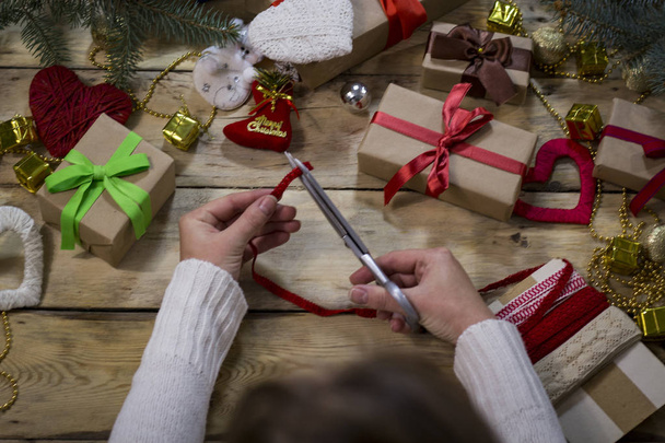 The process of packing gifts for the New Year and Christmas. Wom - Foto, afbeelding