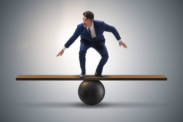 Επιχειρηματίας προσπαθεί να ισορροπήσει σε μπάλα και τραμπάλα - Φωτογραφία, εικόνα