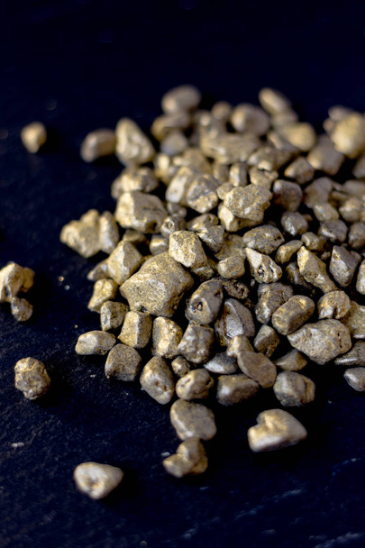 Пісок із золота на дошці з чорного каменю
 - Фото, зображення