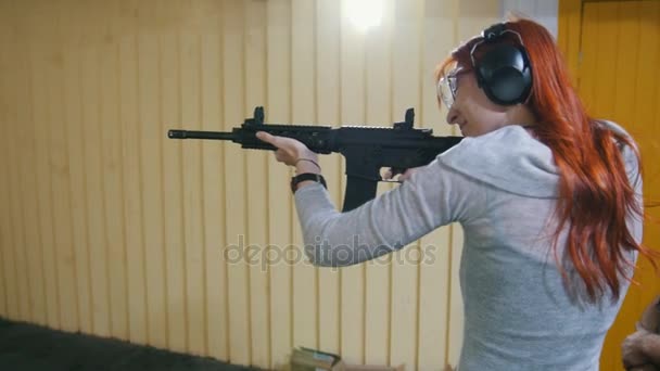 Mulher atirando com uma arma Mashin na galeria de tiro
 - Filmagem, Vídeo