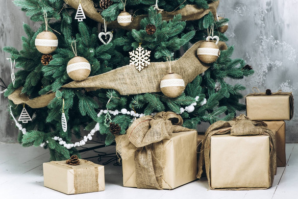 Ajándék dobozok díszített modern karácsonyfa alatt sok. Karácsonyi és újévi koncepció - Fotó, kép