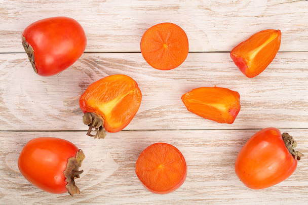 persimmon on white wooden background. Top view. Flat lay pattern - Fotoğraf, Görsel