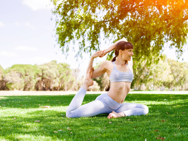 Young woman practicing yoga in the park - Foto, immagini
