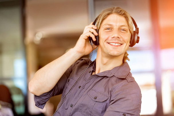 Young man in the office with headphones - Foto, Imagem