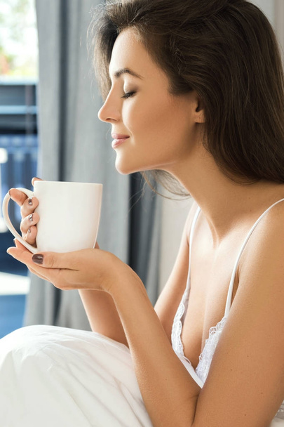 woman drinking coffee in bedroom  - Foto, Imagem