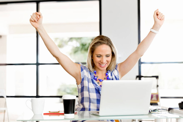 One young woman in office celebrating success - Photo, Image