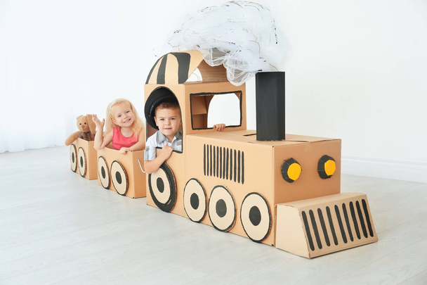 Little children playing with cardboard train in light room - Zdjęcie, obraz