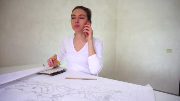 Architecte travaillant à la maison, jeune femme assise près de la table et discutant de l'ordre des clients
 - Séquence, vidéo