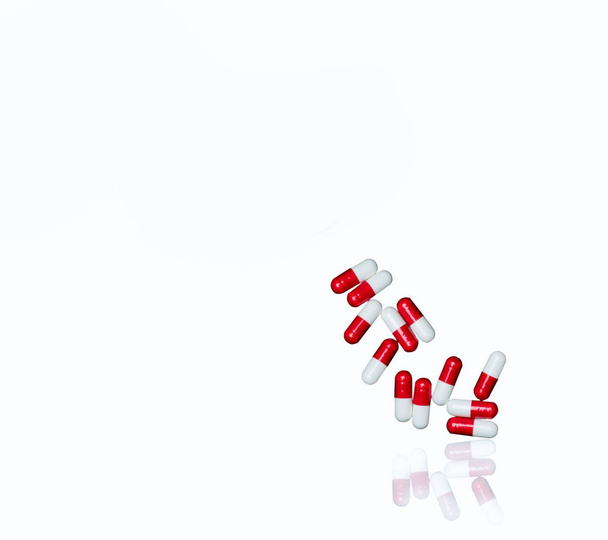 Červená, bílá antibiotikum kapsle prášky izolovaných na bílém pozadí s kopií prostor a ořezové cesty. Lékové rezistence, užívání antibiotik drog s rozumnou koncepcí. - Fotografie, Obrázek