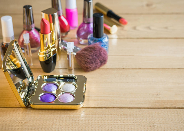 Oog schaduw- en gereflecteerd in de spiegel lippenstift op een vintage rustieke tafel. - Foto, afbeelding