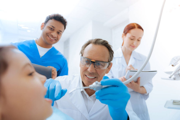 Cheerful professional dentist doing his job - Photo, image