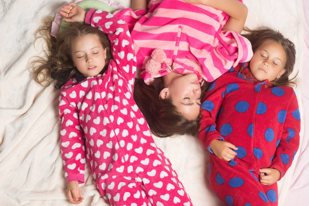 Sisters or friends in pajamas sleep in bed, top view - Photo, Image