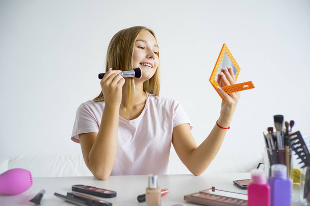Girl applying makeup - Фото, зображення